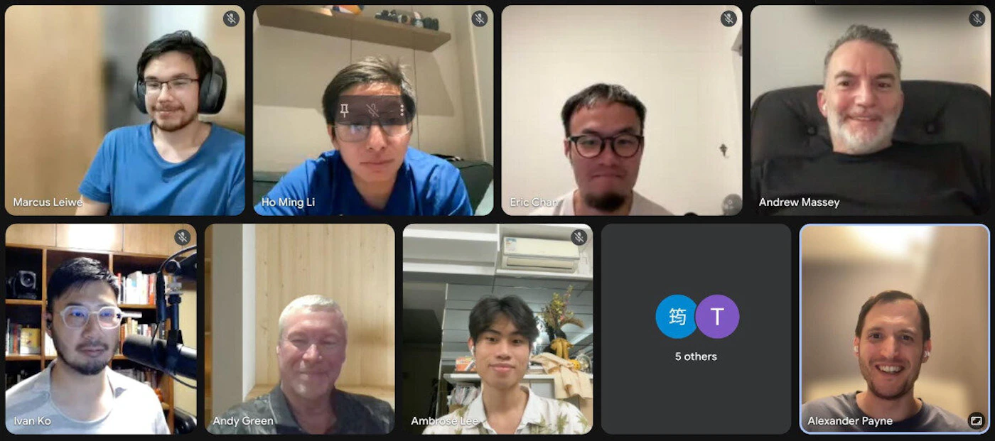 (Photo) A screenshot of a video conference call displaying a grid of nine participant tiles, with most showing individuals and their names, and one tile indicating '5 others'. The participants are mostly men, appearing in various indoor settings. Text: Marcus Leiwe Ho Ming Li Eric Chan Andrew Massey Ivan Ko Andy Green Ambrose [unreadable] 筠 T 5 others Alexander Payne Multiple people in a video conference | Predominantly indoor, showing individual rooms or office spaces | Nine participant tiles, including one placeholder for '5 others' with two initial icons (one Chinese character and one 'T'). Most participants have their names displayed at the bottom of their respective tiles. | Screenshot, candid, digital interface | Colors: #3C4043, #8AB4F8, #FFFFFF, #F0F0F0, #4285F4 Note: The image is a direct capture of a digital interface showing multiple real individuals in a video conference setting, which is characteristic of a photograph.