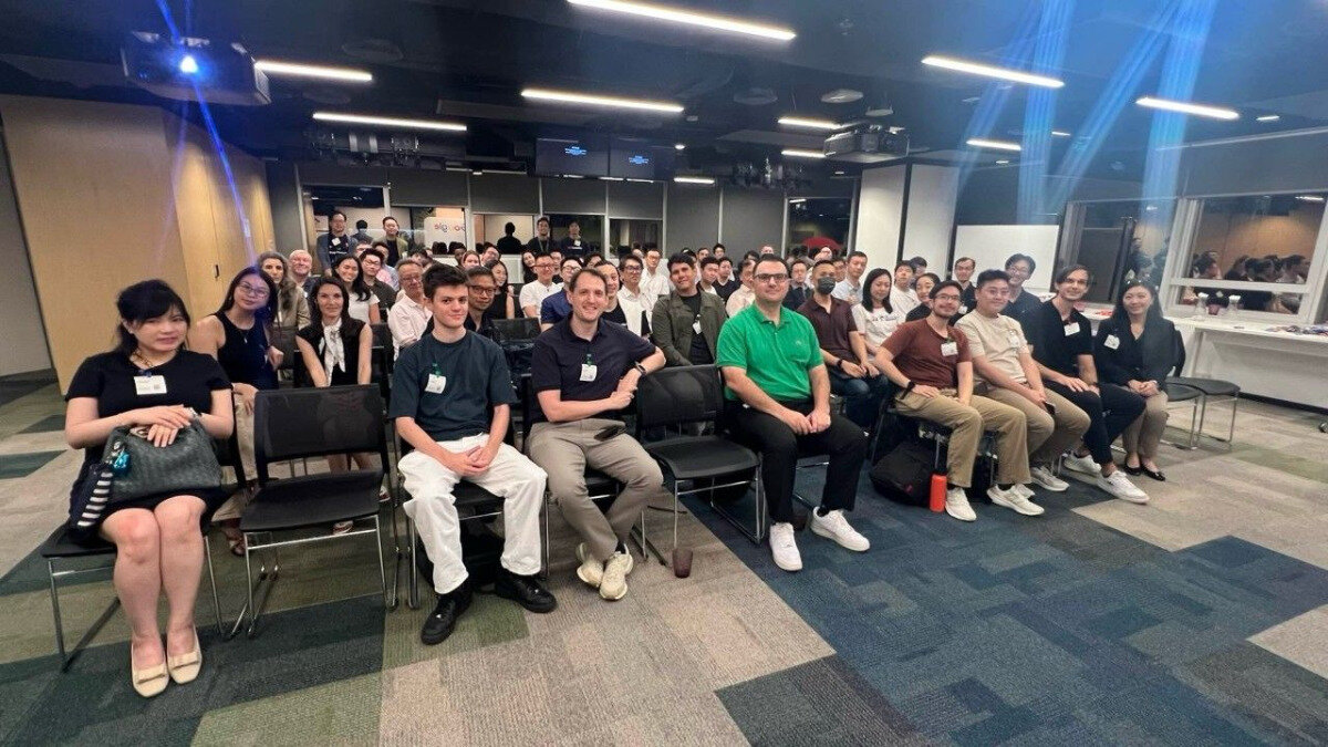 A group of people are seated in rows within an office or event space, posing for a group photograph.. Text: Tencent, big-o