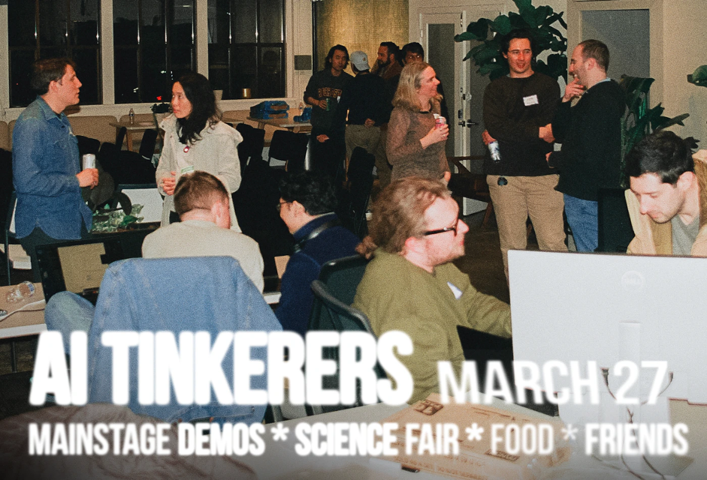 (Photo) The image shows a group of people gathered indoors, possibly at a tech event. The text overlay suggests it's related to AI Tinkerers and a science fair. Text: AI TINKERERS MARCH 27 MAINSTAGE DEMOS * SCIENCE FAIR * FOOD * FRIENDS group of people | indoor | multiple people, text overlay | candid | Colors: #D3D3D3, #A9A9A9, #808080 Note: The image depicts a real-life scene with people in an indoor setting, indicating it's a photograph rather than an illustration or banner. The text is overlaid on the photo.