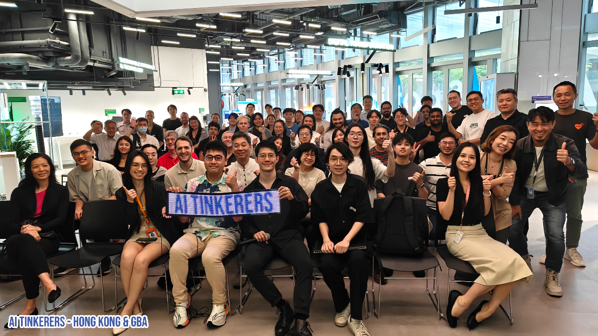 This is a photo of a large group of people posing for a picture indoors. Many are giving a thumbs-up, and some are holding a sign that says 'AI TINKERERS'.. Text: AI TINKERERS
AI TINKERERS - HONG KONG & GBA