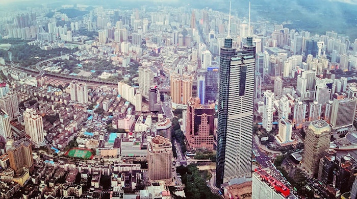 An aerial view of a densely populated cityscape with numerous skyscrapers and other buildings.