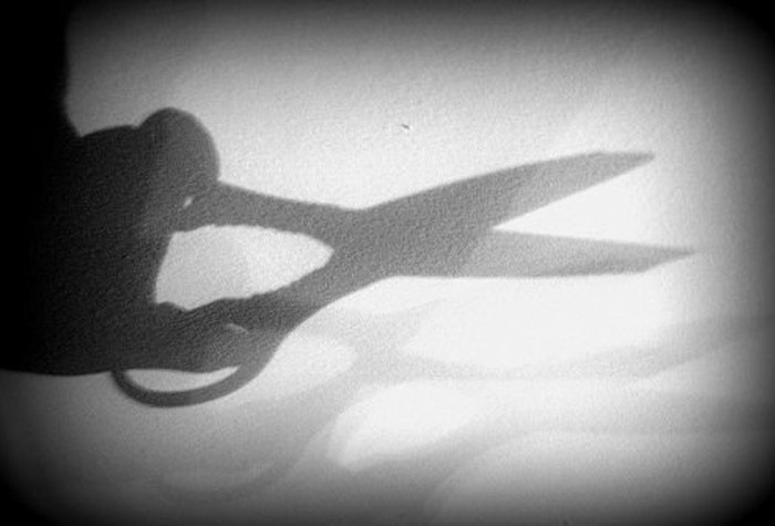 A black and white photo of the shadow of a pair of scissors.
