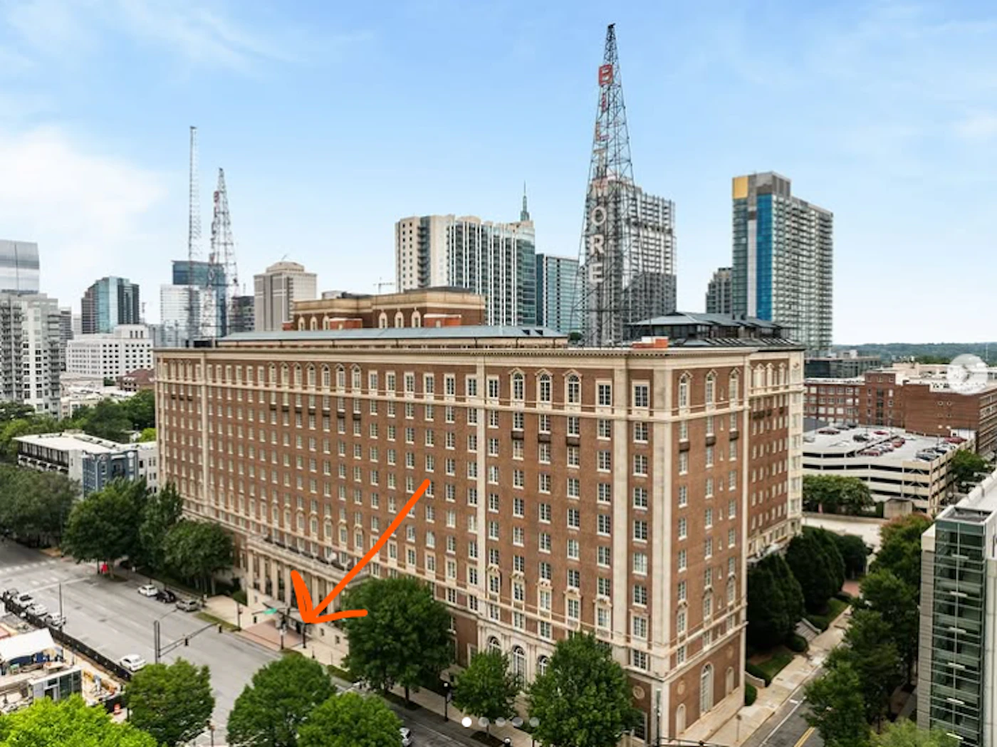 (Photo) A high-angle, wide shot of a large brick building in a city setting.  Other buildings and a radio tower are visible in the background. Text: MORE buildings, city | outdoor | cityscape, radio tower | wide shot, high angle Note: The image is a real-world photograph capturing a cityscape. It showcases buildings and their surroundings.