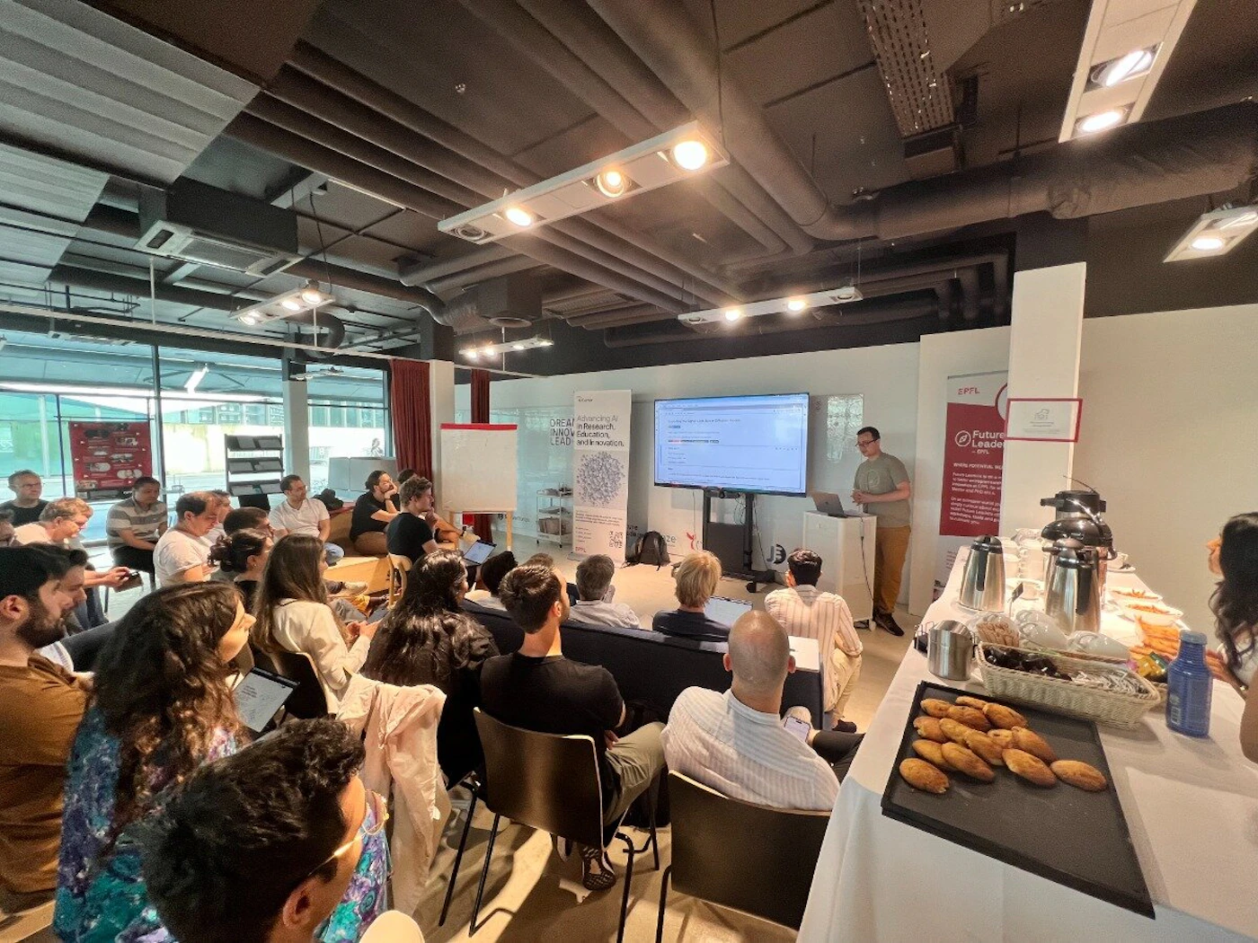 (Photo) A group of people are seated in an indoor space, watching a presentation displayed on a large screen.  A presenter stands next to the screen, seemingly addressing the audience. Text: CAREERS in Research Software Engineering with the LSST people | indoor | presentation, audience, screen | candid Note: The image is a real-life capture of an event, showing a presentation and an audience. This clearly falls under the category of a photograph.