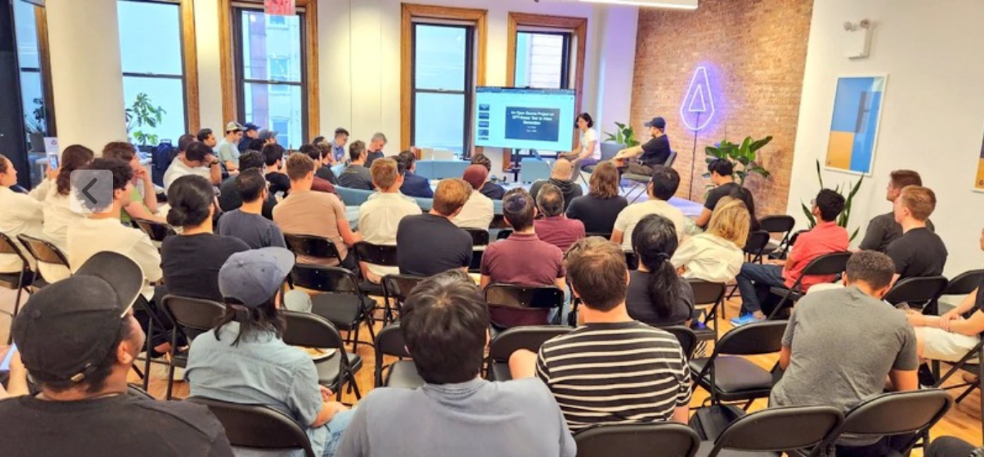 (Photo) A photo of a group of people sitting in chairs, facing a speaker and a presentation screen. people | indoor | presentation, audience, speaker | candid Note: The image is a real-life captured scene of an event with people, thus categorizing it as a photo. It's not a logo, illustration, banner, or handwriting.