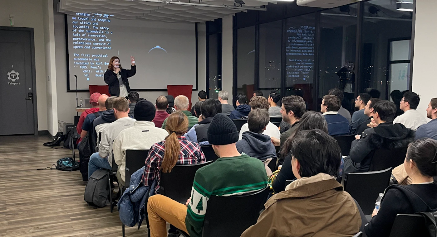 (Photo) A photograph captures a speaker presenting in front of a projector screen to an audience seated in rows. The setting appears to be an indoor event space with large windows overlooking a city skyline at night. Text: transfor... making the wa we travel and shaping our cities and societies. The story of the automobile is a tale of innovation, perseverance, and the relentless pursuit of speed and convenience. The first practical automobile was invented by Karl Ben in 1885. Benz's obili with vol dust 1 Teleport a speaker giving a presentation to an audience | indoor, modern event space or office, at night | multiple people, projector screen with text and a graphic, city lights visible through windows, speaker gesturing | candid, event photography | Colors: #4A4A4A, #D3D3D3, #8B4513, #FFFFFF, #000000 Note: This image is a direct capture of a real-world scene, featuring people and an environment, which is characteristic of a photograph. It is not a graphic design, drawing, or a scanned document.