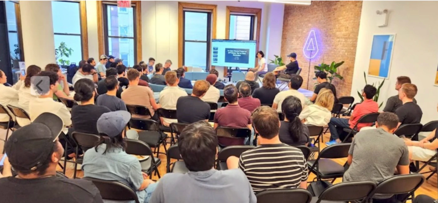 (Photo) A photo of a group of people sitting in chairs, facing a screen at the front of the room.  It appears to be a presentation or lecture. people | indoor | presentation, audience, screen | candid Note: The image is a real-life captured image of a scene with people, making it a photograph. It's not a drawing, logo, or banner.