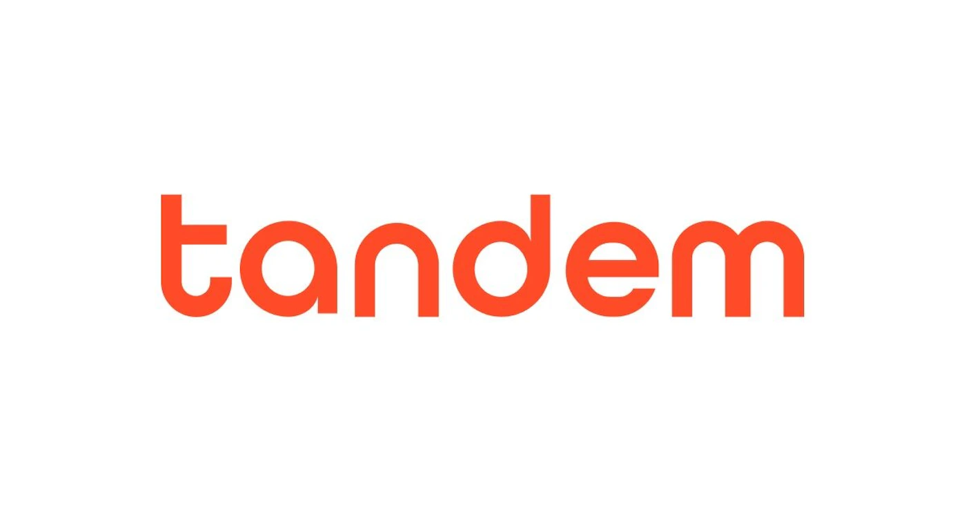 (Logo) The image features the word 'tandem' in a stylized, lowercase, orange-red font centered on a plain white background. Text: tandem Colors: #FF4520, #FFFFFF Note: The image consists of a single word in a distinctive, stylized typeface, which is a classic representation of a wordmark logo.