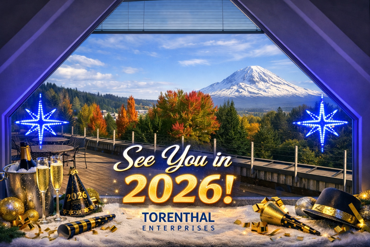 A festive New Year's greeting banner featuring a composite image of champagne, party supplies, and a scenic view of a snow-capped mountain through a window. The image promotes the year 2026 and includes the name Torenthal Enterprises.. Text: See You in 2026! TORENTHAL ENTERPRISES 2026
