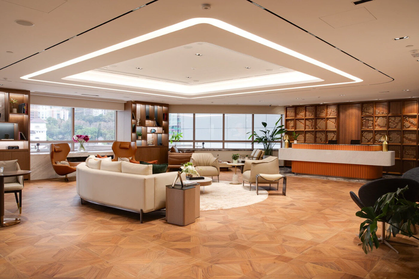 (Photo) A photo of a modern, spacious office lobby or waiting area with a variety of seating, a reception desk, and large windows. interior space | indoor | reception desk, waiting area, modern furniture, large windows | wide-angle, architectural | Colors: #a57858, #f2e9e1, #f08c4a Note: The image is a real-world photograph of an interior space, depicting furniture, decor, and architectural elements.
