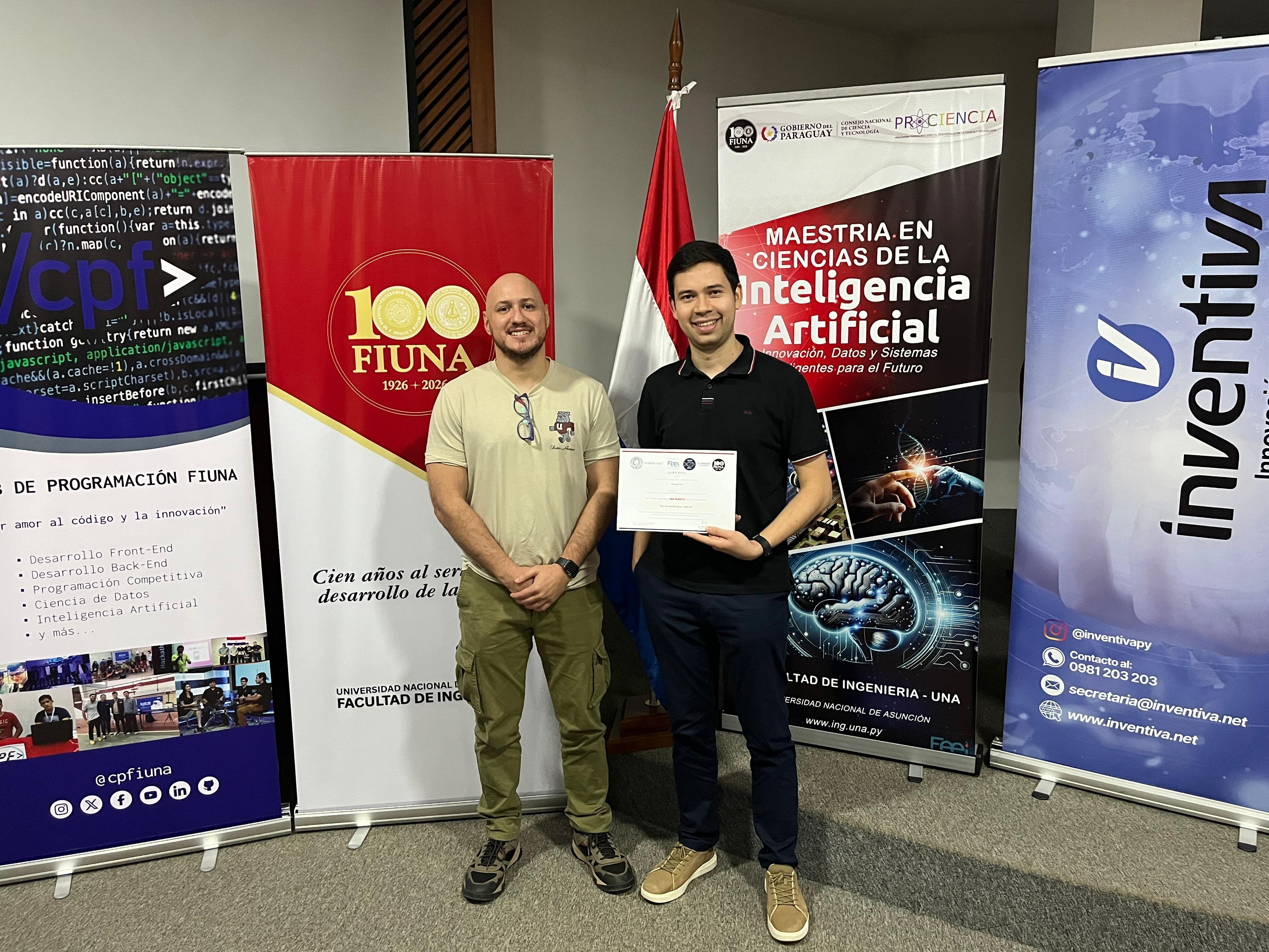 (Photo) Two men posing for a photo in front of several promotional banners at what appears to be an academic or technology event, with one man holding a certificate. Text: cpf > S DE PROGRAMACIÓN FIUNA amor al código y la innovación Desarrollo Front-End Desarrollo Back-End Programación Competitiva Ciencia de Datos Inteligencia Artificial y más... @cpfiuna 100 FIUNA 1926 - 2026 Cien años al servicio del desarrollo de la... UNIVERSIDAD NACIONAL DE ASUNCIÓN FACULTAD DE INGENIERÍA GOBIERNO DEL PARAGUAY CONACYT PROCIENCIA MAESTRÍA EN CIENCIAS DE LA INTELIGENCIA ARTIFICIAL Innovación, Datos y Sistemas Inteligentes para el Futuro FACULTAD DE INGENIERÍA - UNA www.ing.una.py inventiva @inventivapy 0981 203 203 secretaria@inventiva.net www.inventiva.net people at an event | indoor | pull-up banners, national flag, certificate, academic setting | posed portrait | Colors: #FFFFFF, #000000, #D32F2F, #1976D2 Note: The image is a captured photograph of two individuals at an indoor event venue, characterized by natural lighting and real-world subjects.